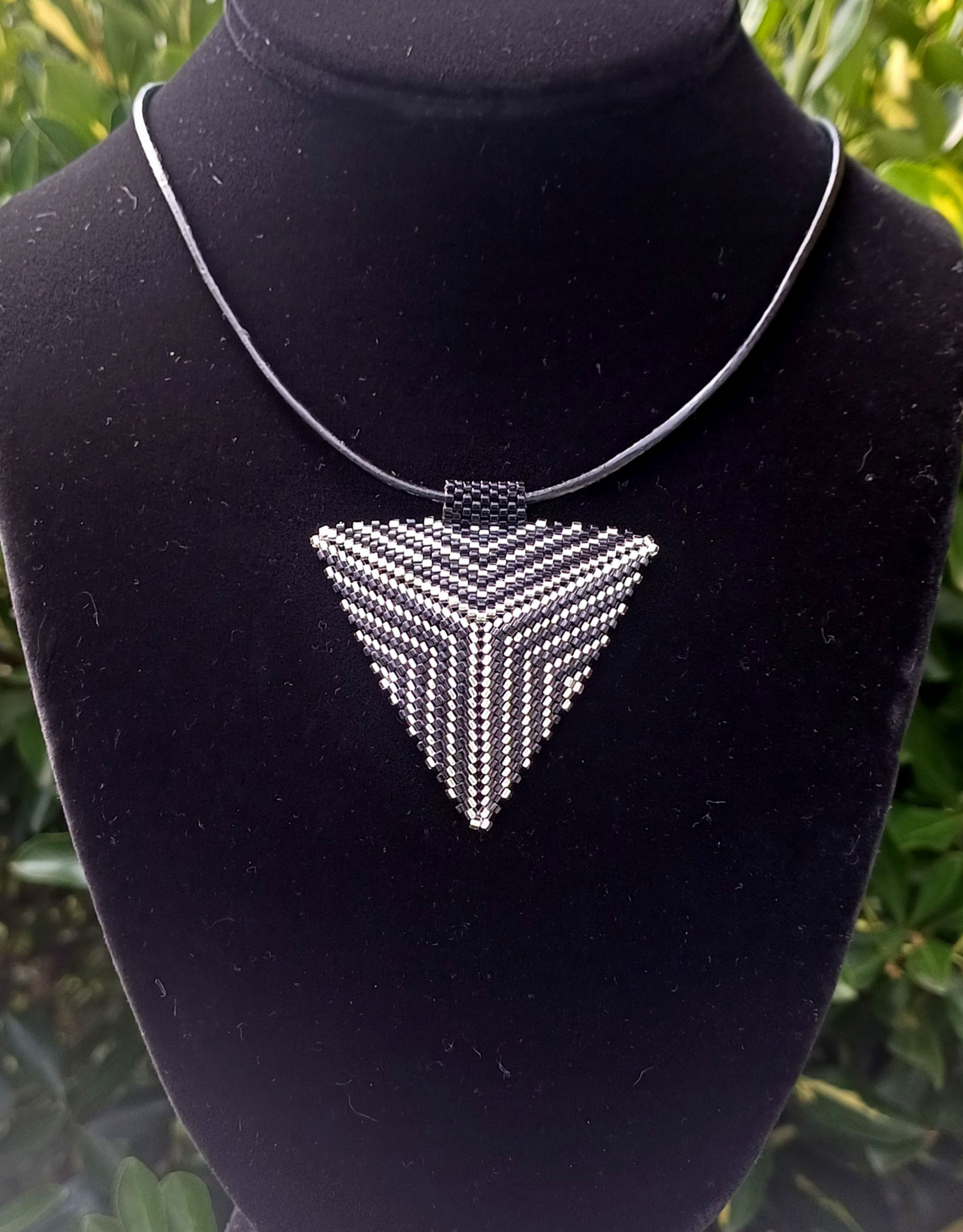 black and silver seed beaded triangle pendant and bail on a black leather cord