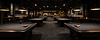 Wide interior view of a polished East Texas billiards venue with aligned pool tables and warm lighting