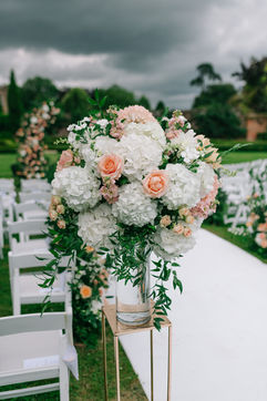 White hydrangeas and peach roses wedding aisle arrangement