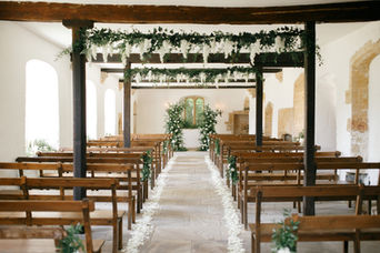 Rustic wedding chapel with wooden pews and floral archway