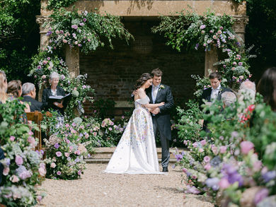 Bride and groom standing at a flower-adorned wedding altar.