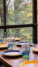 Sequester yourself from summer insects and stormy weather when you set the table for meals on our enclosed screened porch with wood picnic table set with blue and yellow plates and looking into the autumn green and yellow forest.