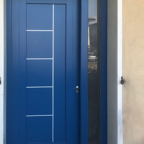 Portoncino d'ingresso moderno in PVC blu con sottili inserti orizzontali metallici, luce laterale fissa in vetro e serratura di sicurezza.