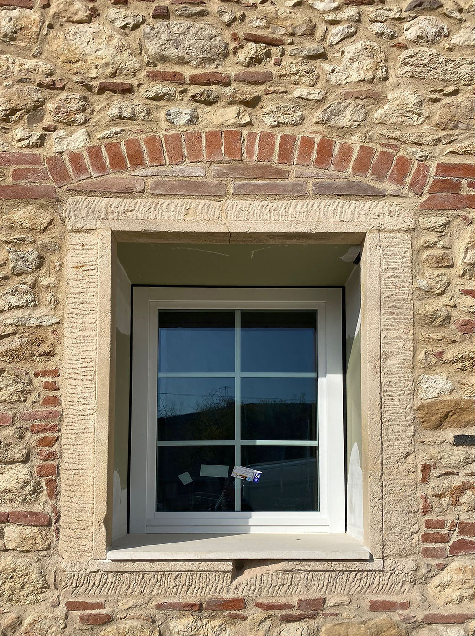 Esempio di installazione di finestra con inglesine bianche su muro antico in pietra. Soluzione ideale per mantenere uno stile classico e tradizionale in edifici rustici o casali ristrutturati.