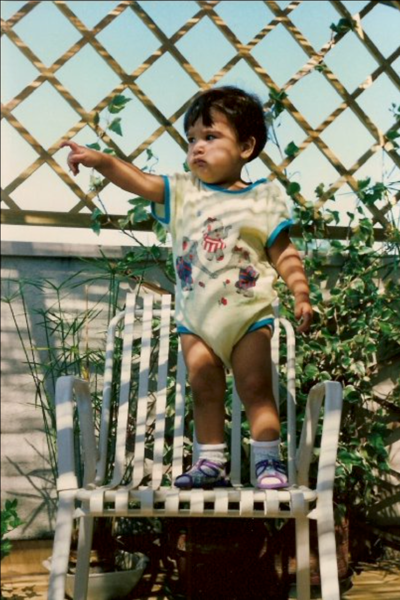 Portrait-of-Luana-Martignon-as-a-toddler-stood-on-a-chair-pointing-at-something