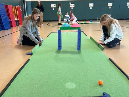 Kid setting up a mini golf hole at AW Cox