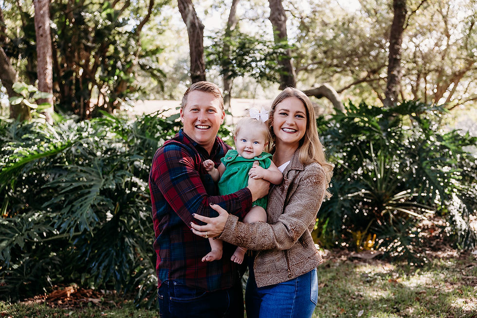 Happy family portrait with a baby laughing together in a garden in Orlando