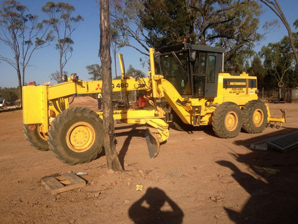 Yellow Mitsubishi MG460 motor grader on a construction site