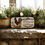 Thumbnail: staged image of product in a rock garden area Welcome to our Farmhouse sign with rooster