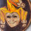 Thumbnail: Smiling jester mask painting with floral accents on wood