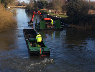 Two work boats dredging a canal