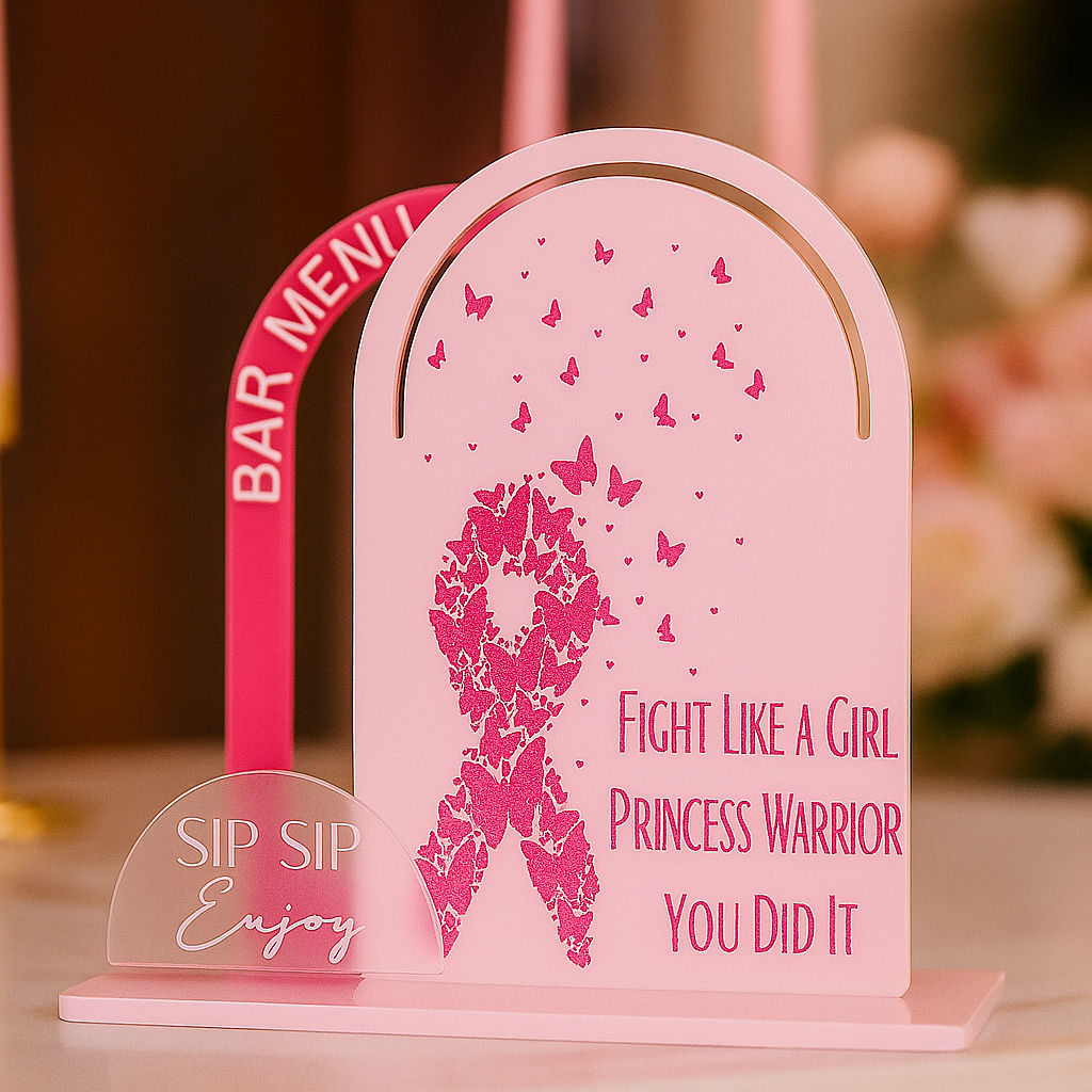 Pink acrylic arch bar sign with a breast cancer ribbon design, butterflies, and empowering text, set against a luxurious pink