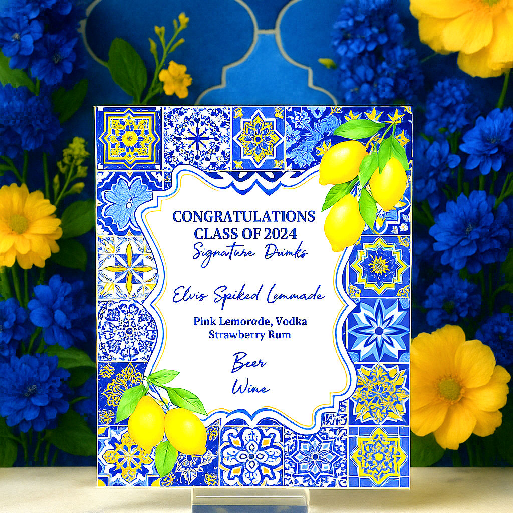 A vibrant Mediterranean-style signature drink sign with lemon accents and blue-and-yellow tile patterns, displayed upright on
