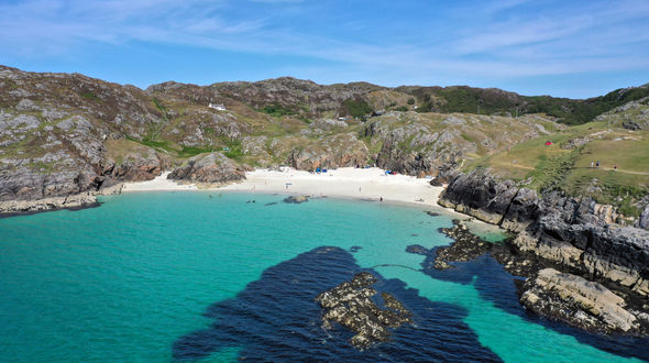 Drone phot of beach bay with golden sands and aqua water