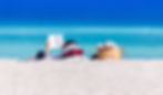 A man reading a book on a beach overlooking the sea.