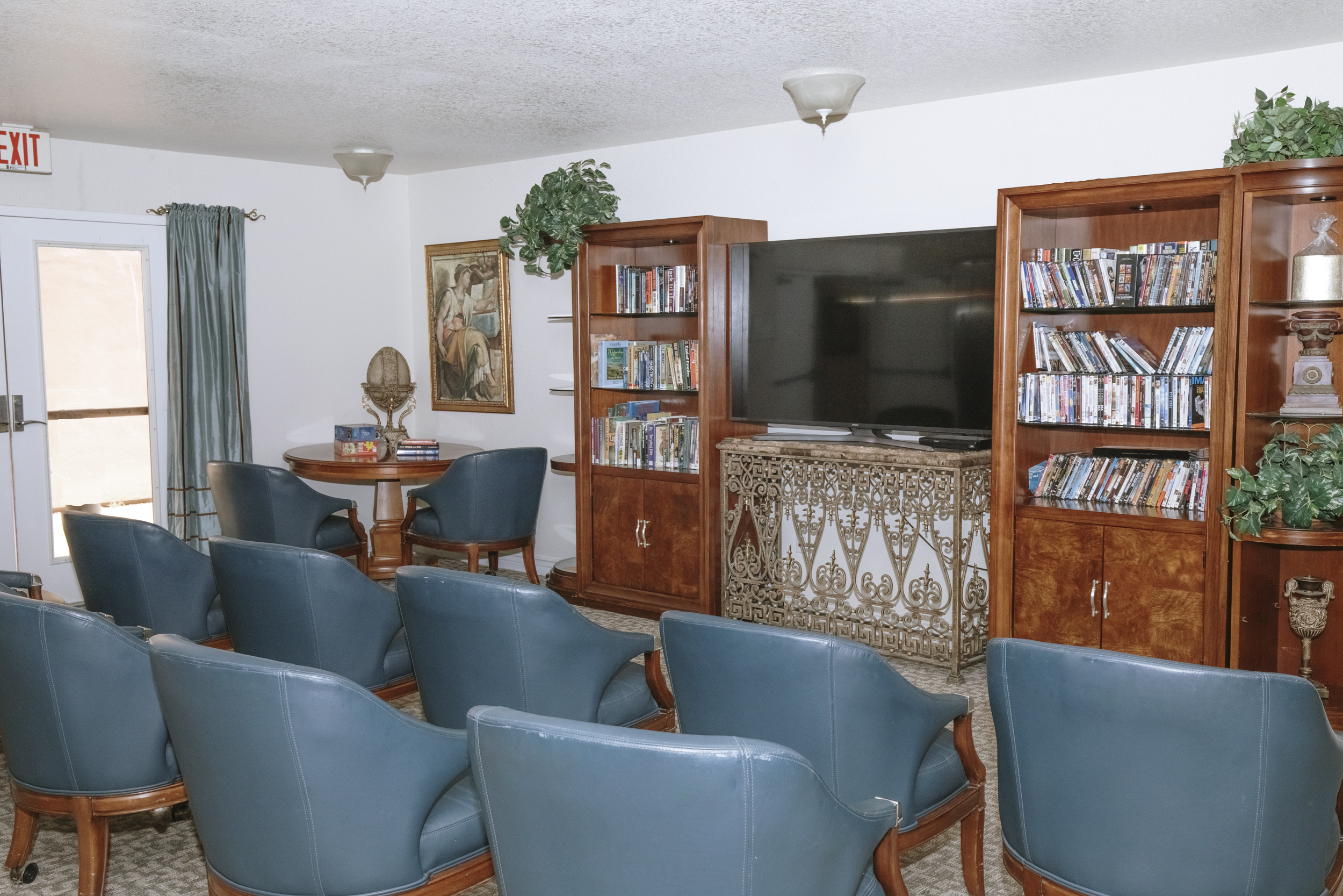 Theater seating facing a television between media shelves.