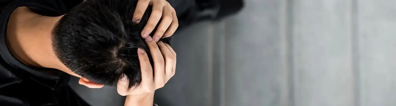 Graphic showing an overhead view of an employee holding their head in stress, overlaid with a mental health statistic.
