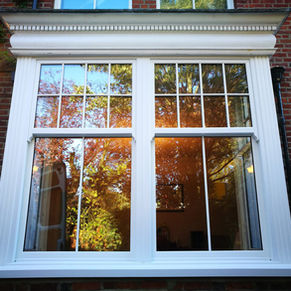 rehau heritage double sliding box sash windows in white upvc with the edwardian design astrigal bars fitted to the face of the glass