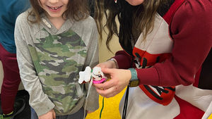 Young girl with teacher holding craft