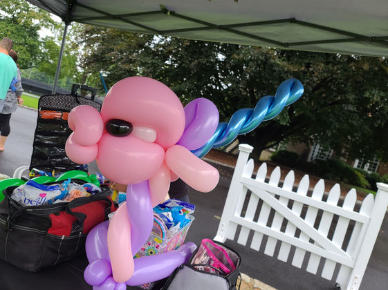Balloon twisters creating fun shapes for children at a summer camp