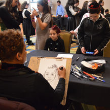 An MME caricature artist drawing a guest’s portrait at an event.
