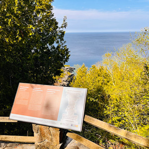 View of Georgian Bay with an interpretive sign (trail sign) in the foreground.