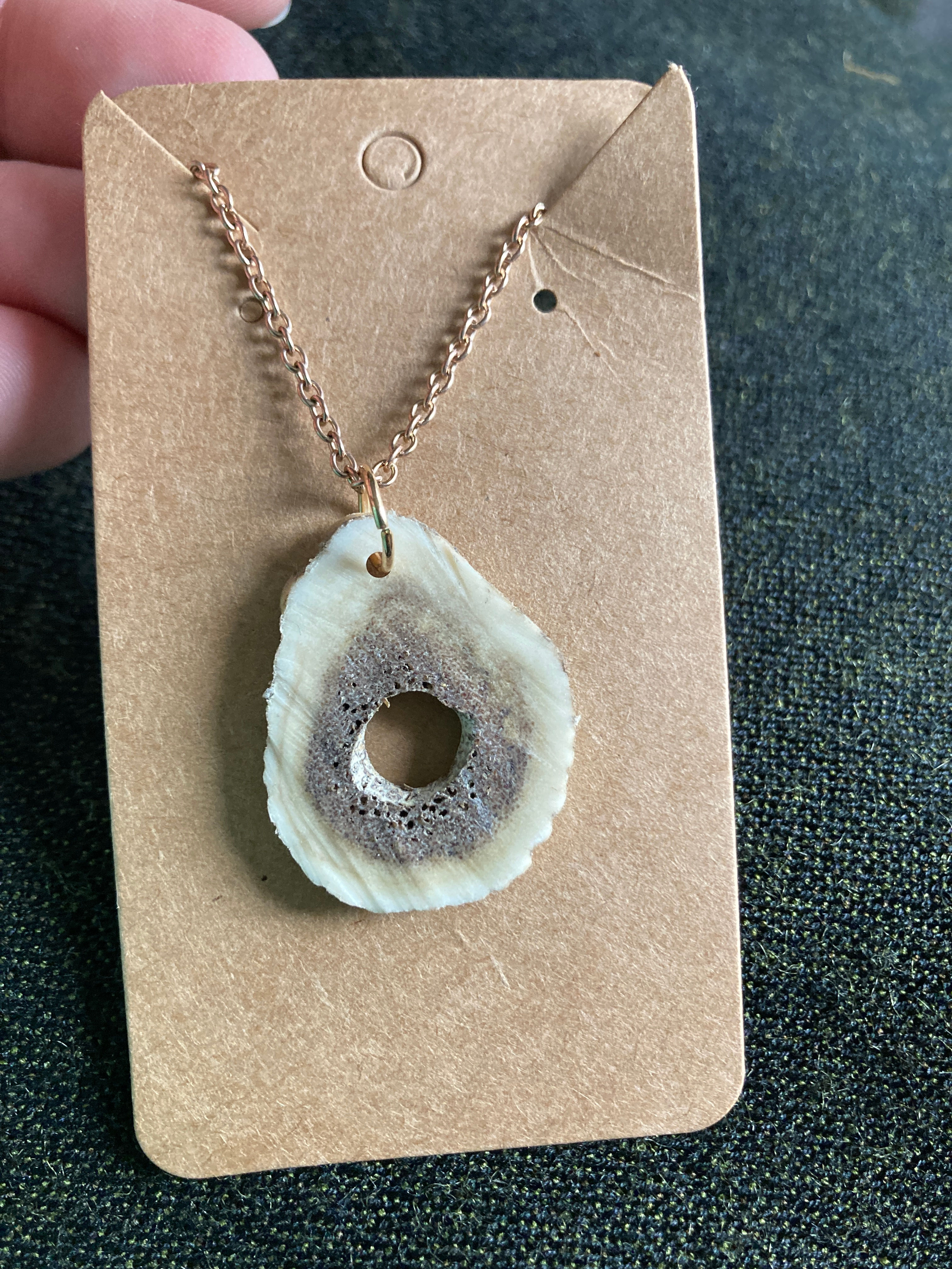 Halsband av dovhjortshorn.  Gyllene kedja.