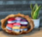 7 balls of Tori yarn in a wooden basket next to a plant