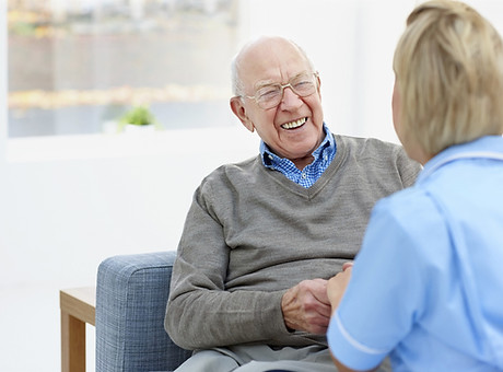 Happy elderly patient talking with a carer at home.jpg
