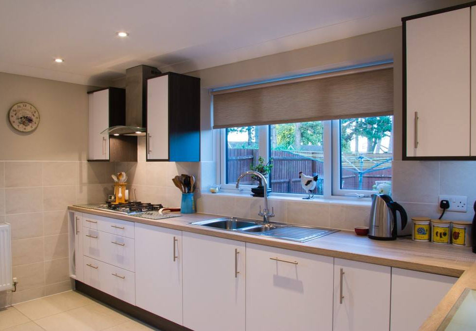 A modern kitchen interior. The kitchen features white, flat-panel base and wall cabinets