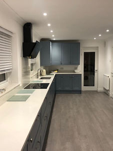 A new kitchen featuring storm blue cabinets and a Fugen Cararra Satinato quartz worksurfaces