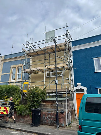 Scaffolding erected on the front of a terraced house under renovation