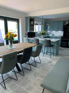 A modern, open-plan kitchen and dining area with shaker-style cabinets