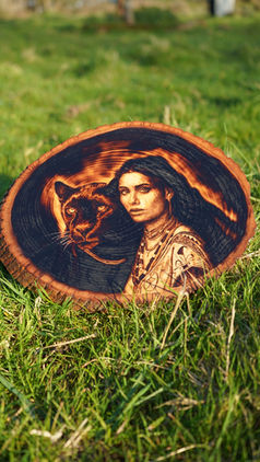 A decorative piece of pyrography art featuring a portrait of a woman alongside a panther,