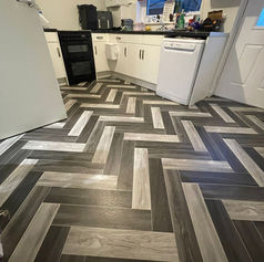 A kitchen with cushion flooring, specifically designed to mimic the appearance of wood or 