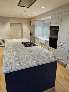 A kitchen featuring a large island with a granite worktop_
