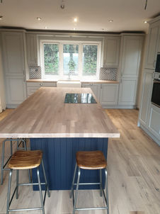 A newly installed bespoke kitchen featuring a large central island and perimeter cabinetry