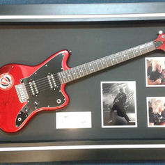 Framed electric guitar with photgraphs
