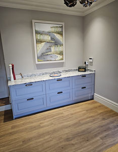 A custom-designed interior space featuring a run of bespoke light blue kitchen cabinets