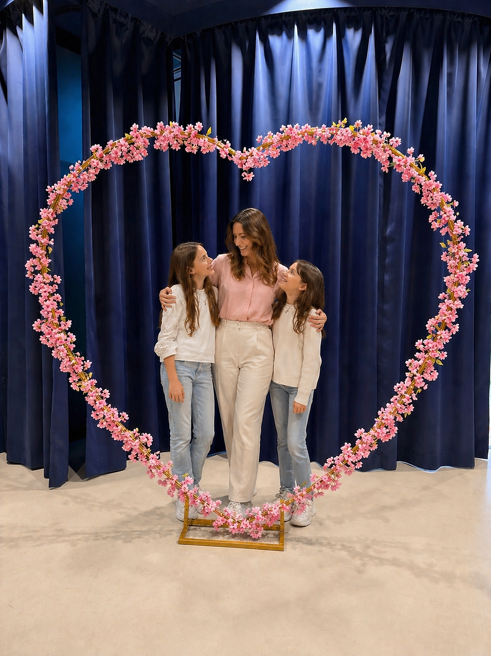 Mother with two children standing inside a large flower heart photo spot at Magic Bavaria Munich, perfect for Mother’s Day family photos