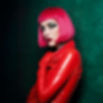woman-draped-in-a-striking-red-leather-outfit-donning-dark-makeup-with-bold-green-eyeshado