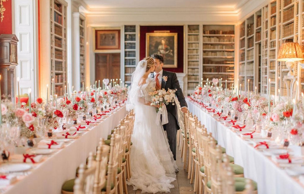 Wide angle view of a stately home wedding reception with red and pink floral decor