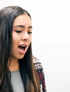 Young woman singing during a vocal lesson — practicing technique with focus and breath control.