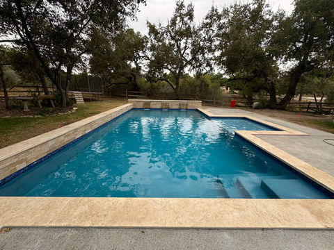 Custom pool and spa in a home backyard in Dripping Springs, Texas. 