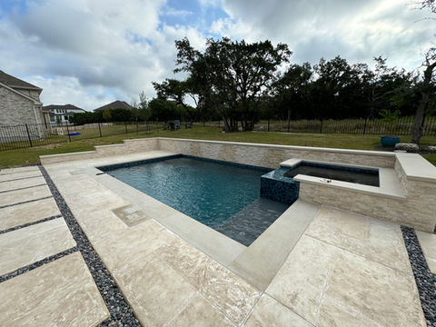 Custom pool and spa in a home backyard in Dripping Springs, Texas. 