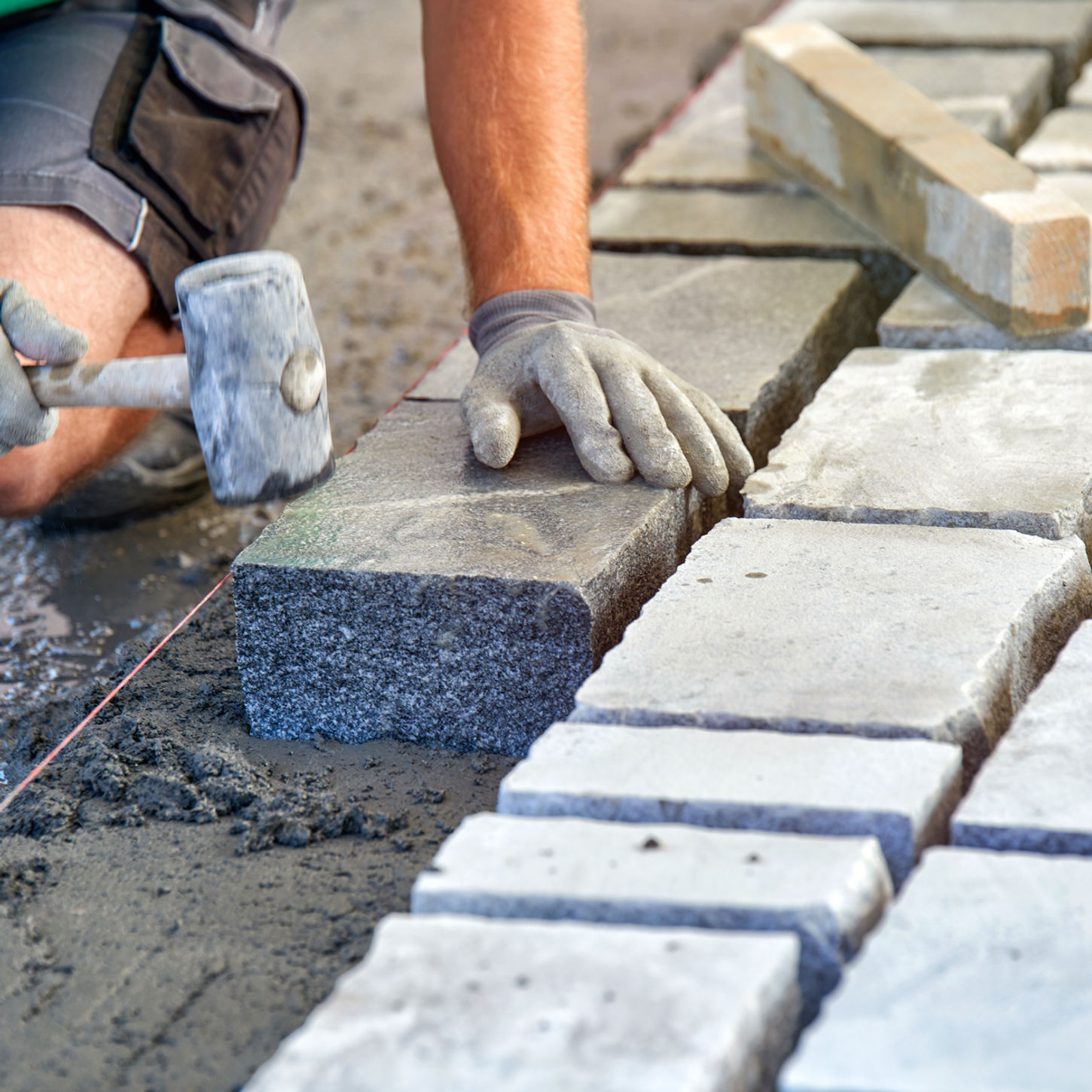 Ein Mann verlegt Pflastersteine