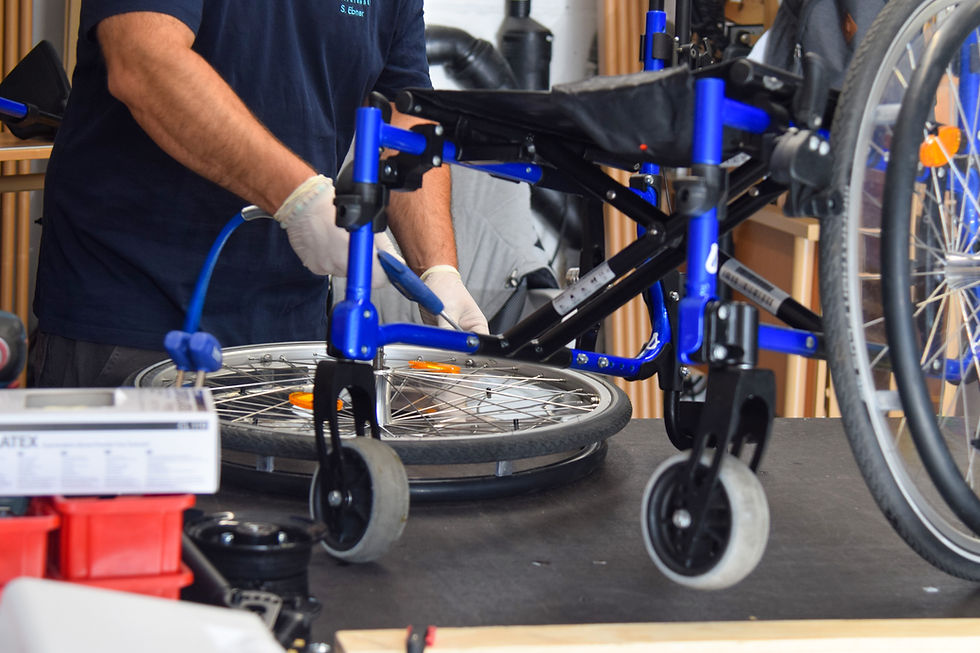 Techniker repariert einen blauen Rollstuhl in der Werkstatt