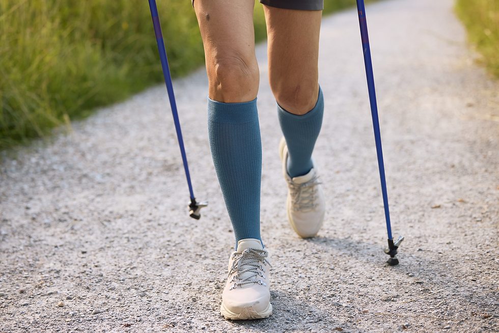Person mit Kompressionsstrümpfen beim Nordic Walking