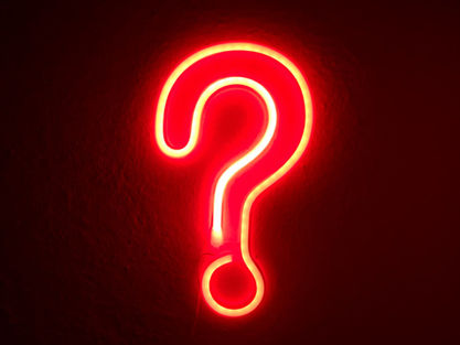 A bright red question mark against a black background