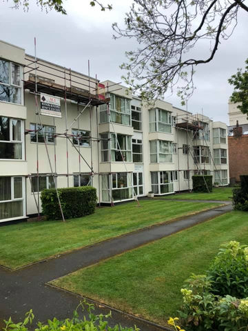 row of buildings with scaffolding and well maintained lawn